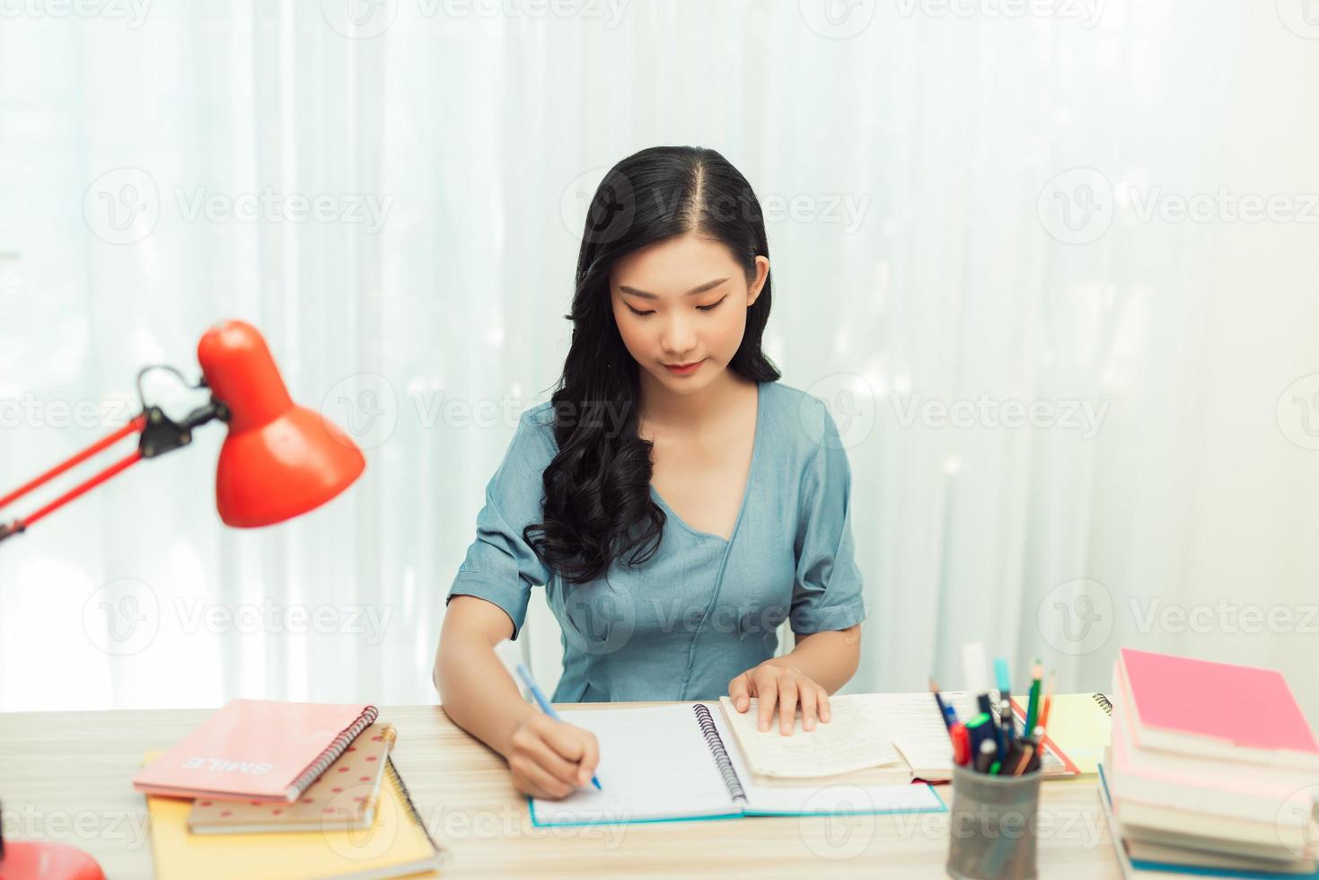 College female student doing research homework assignment making notes learning photo