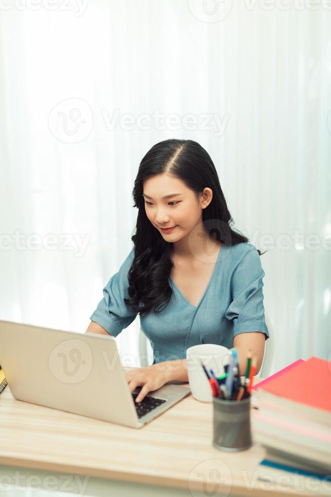 Young female gardener in glasses using laptop, communicates on internet photo