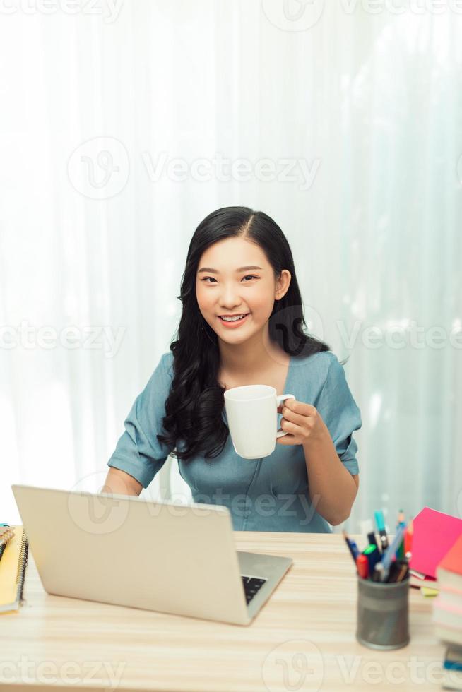 Free Time. Young woman in glasses reading book sitting at home, drinking tea, photo