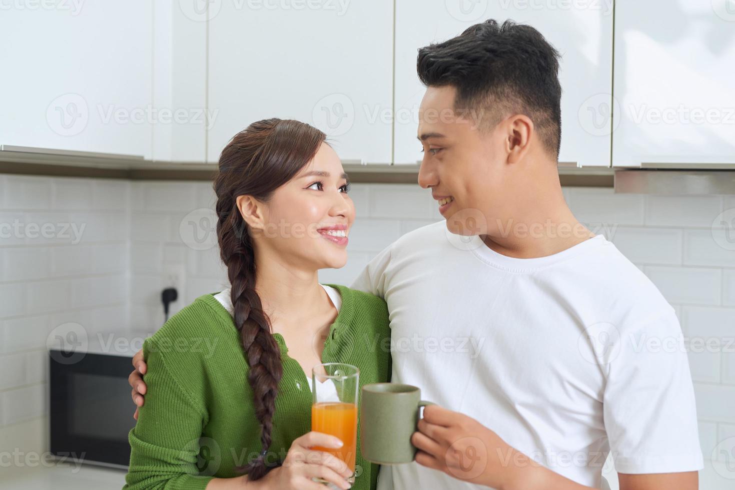 una joven atractiva y un hombre guapo disfrutan pasar tiempo juntos mientras están en una cocina moderna y luminosa. foto