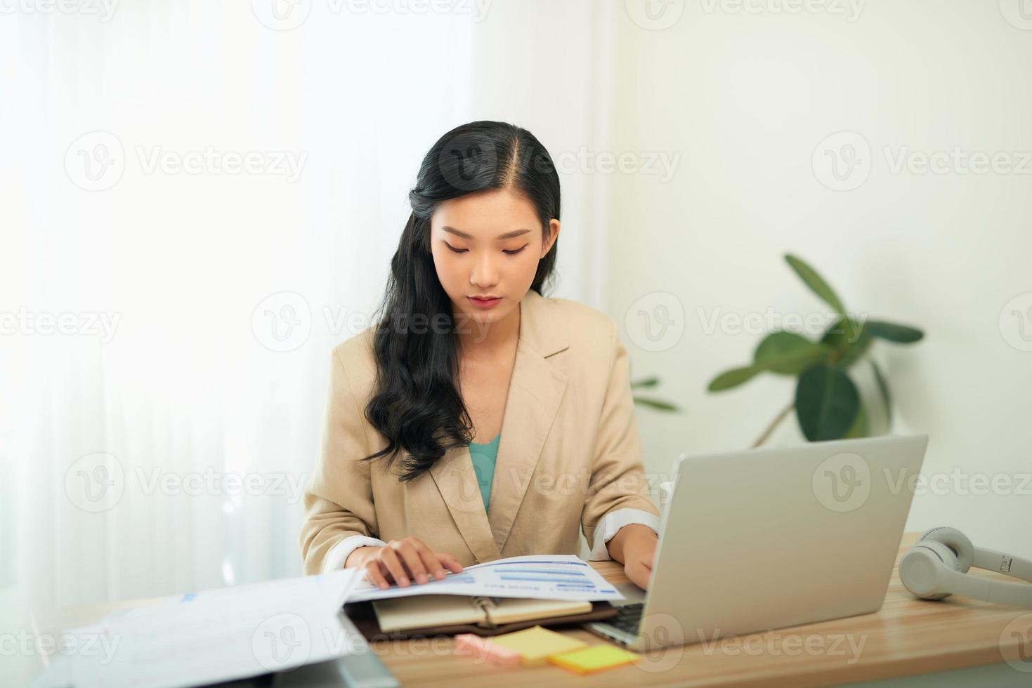 Focused woman journalist freelancer working online on laptop, sitting at desk at home photo