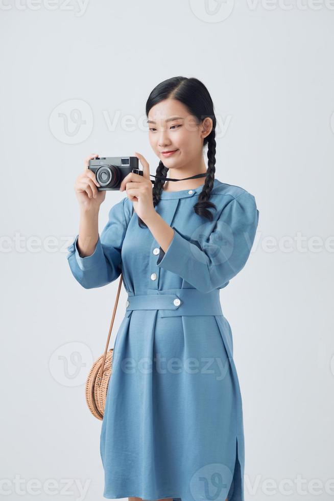 joven fotógrafa tomando fotos para su propia colección y presentación de fotos en cámara retro