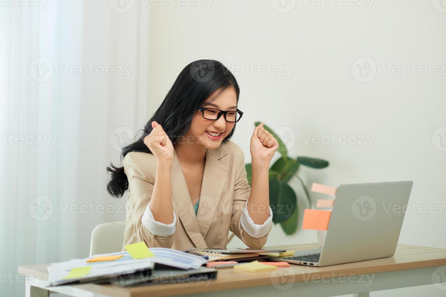 Young girl student winner celebrate victory triumph sit at home desk photo