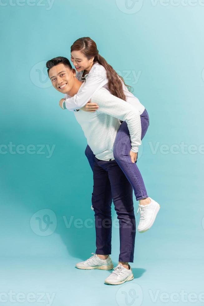 Spending great time together. Happy young man carrying his beautiful girlfriend on shoulders and smiling while standing photo