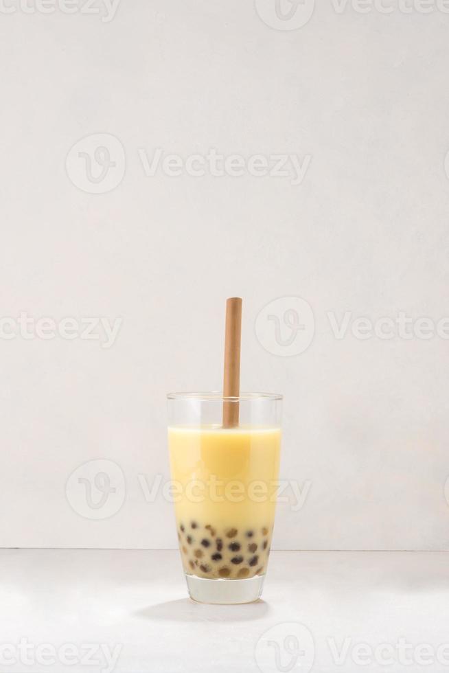 Bubble boba tea with milk and tapioca pearls in glass on white background photo