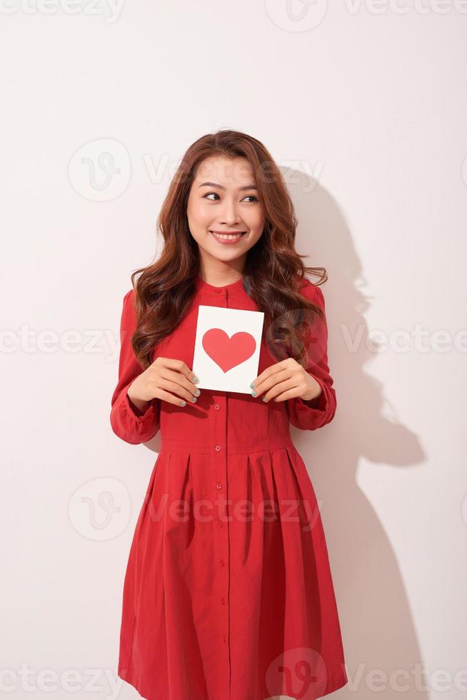 Portrait of happy romantic girl with red paper heart-shaped postcard, romantic wishes, Valentine day celebration, love concept photo
