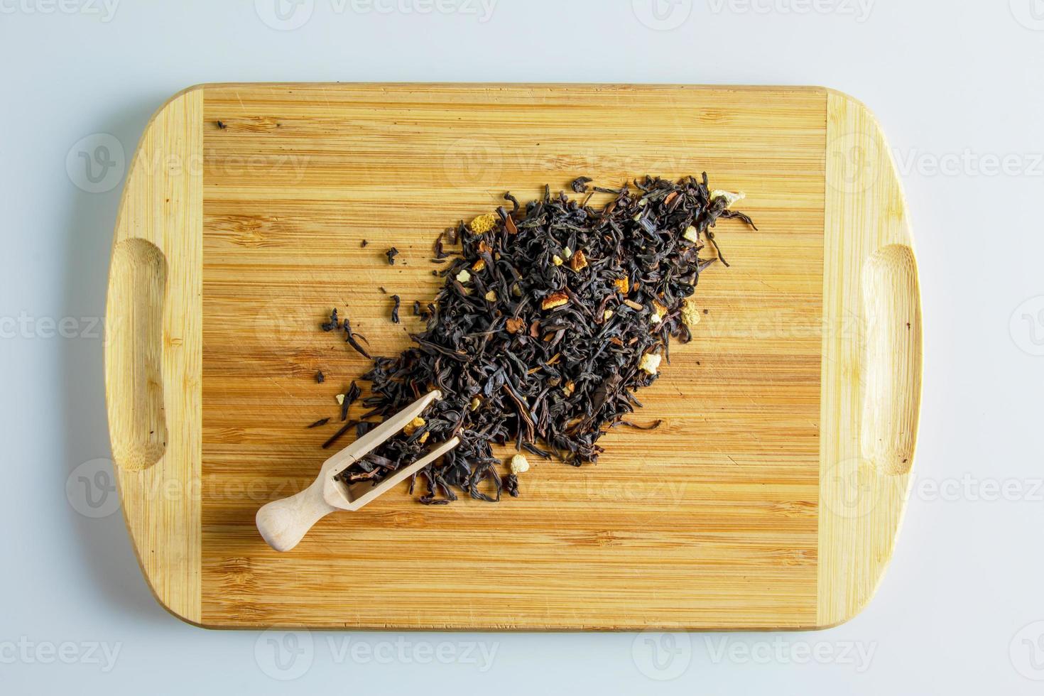 Dry tea based on black with pieces of citrus orange and lemon on a wooden background. photo