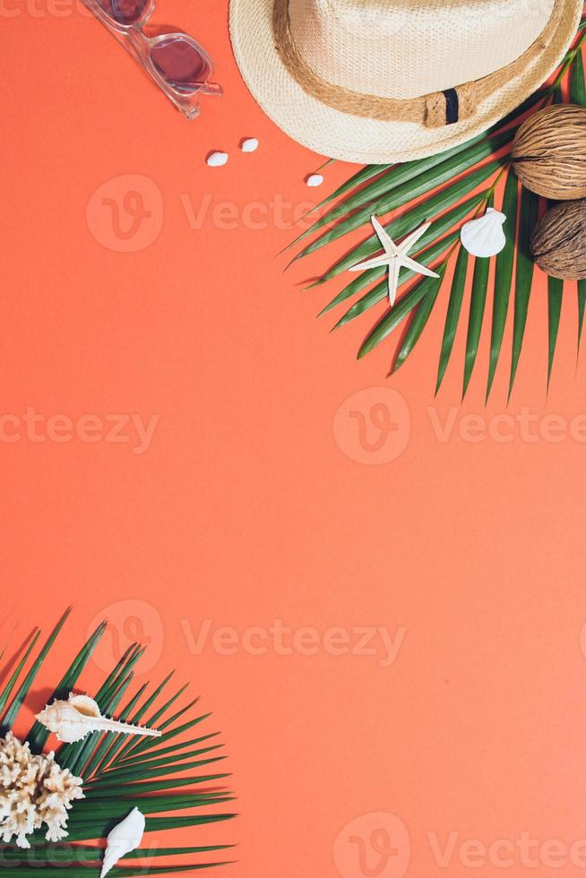 Flat lay of sunglasses, hat, coconuts with palm branches and shells photo