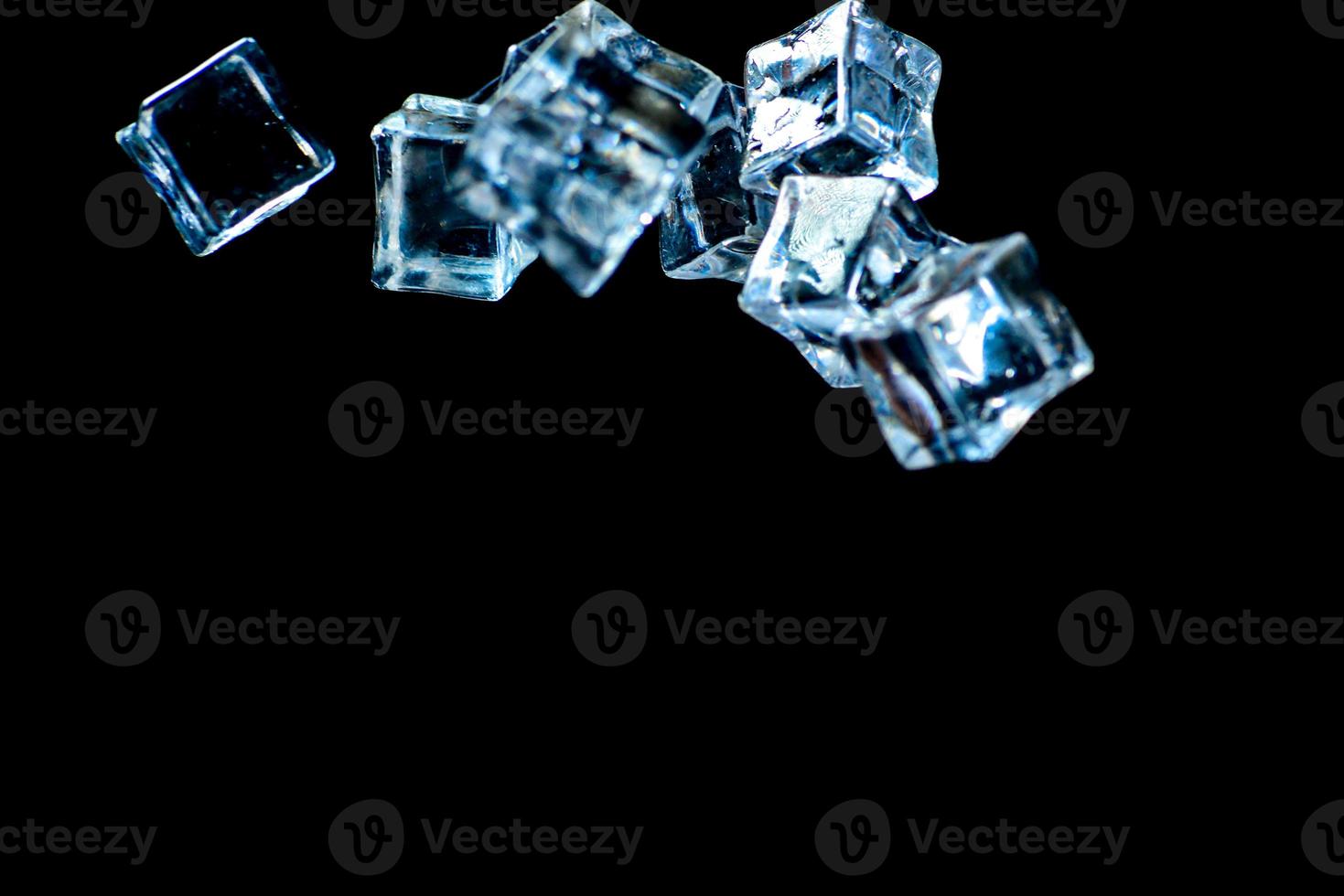 Ice cubes on a black background. ice falling on a black background for use as an illustration in a project photo
