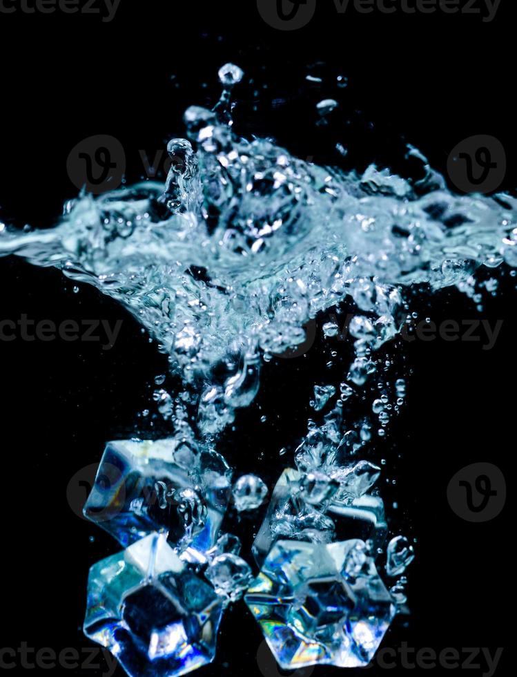 ice cubes in water with bubbles on black background photo