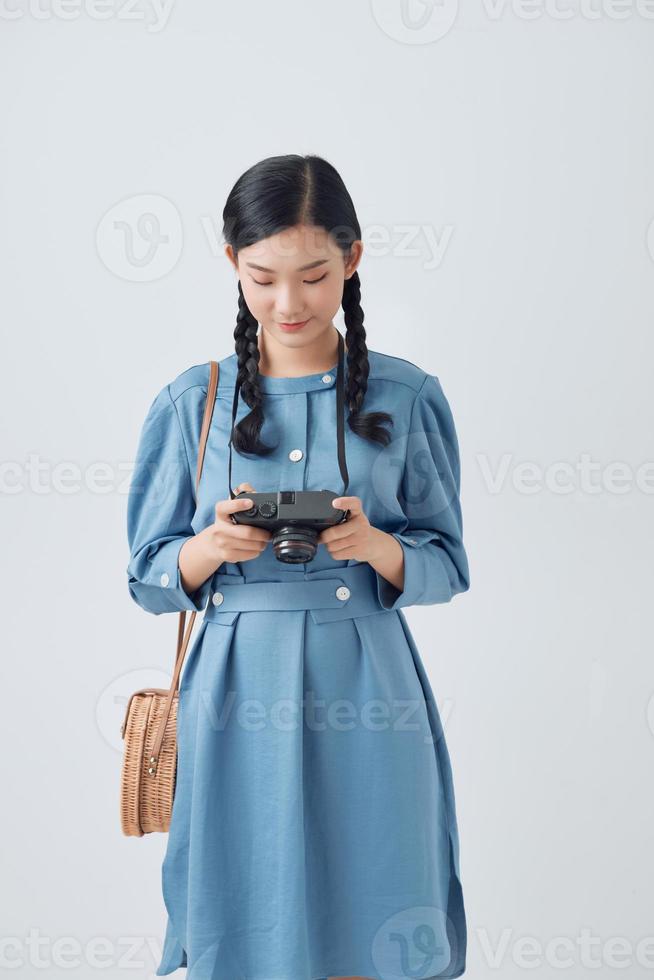 Young woman photographer taking picture for own collection and photo presentation on retro camera