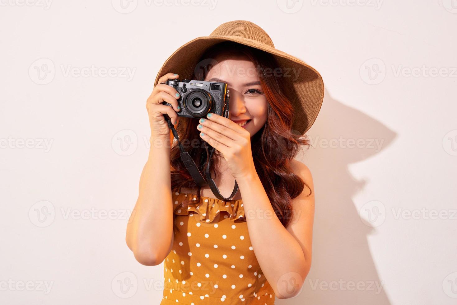 mujer viajera con cámara, fondo beige foto