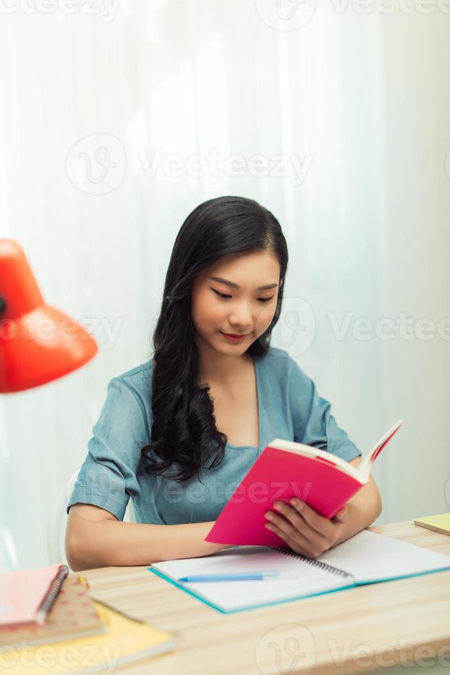 colegiala enfocada estudiando con libros preparándose para el examen de prueba escribiendo un ensayo haciendo la tarea en casa foto