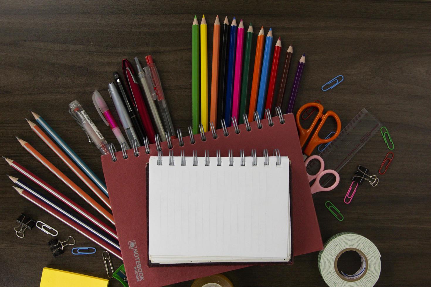 Red Books with color pencils and education elements, back to school concepts on dark wood background. used in poster, brochures photo