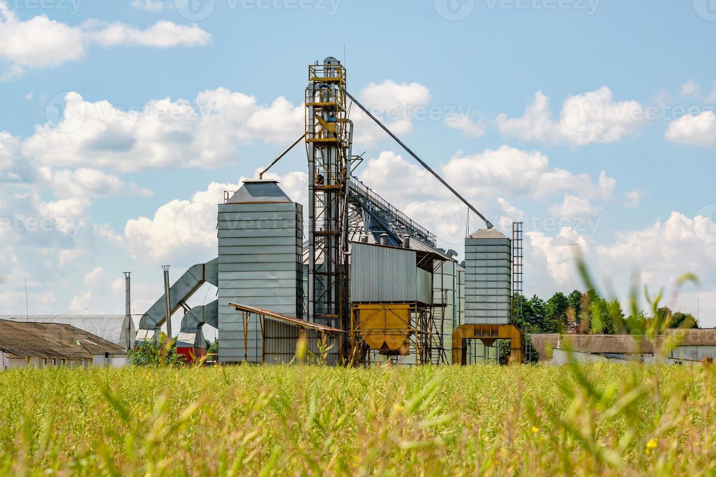 Modern Granary elevator. Silver silos on agro-processing and manufacturing plant for processing drying cleaning and storage of agricultural products, flour, cereals and grain. photo