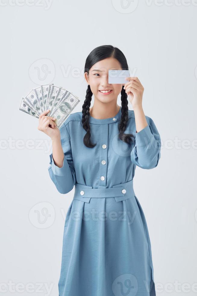 attractive young woman holding dollar banknotes and credit card isolated over white background photo