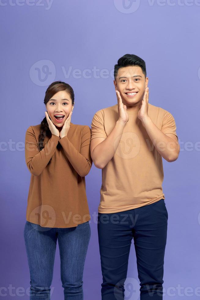 Image of happy friends loving couple standing isolated over purple background screaming looking camera. photo
