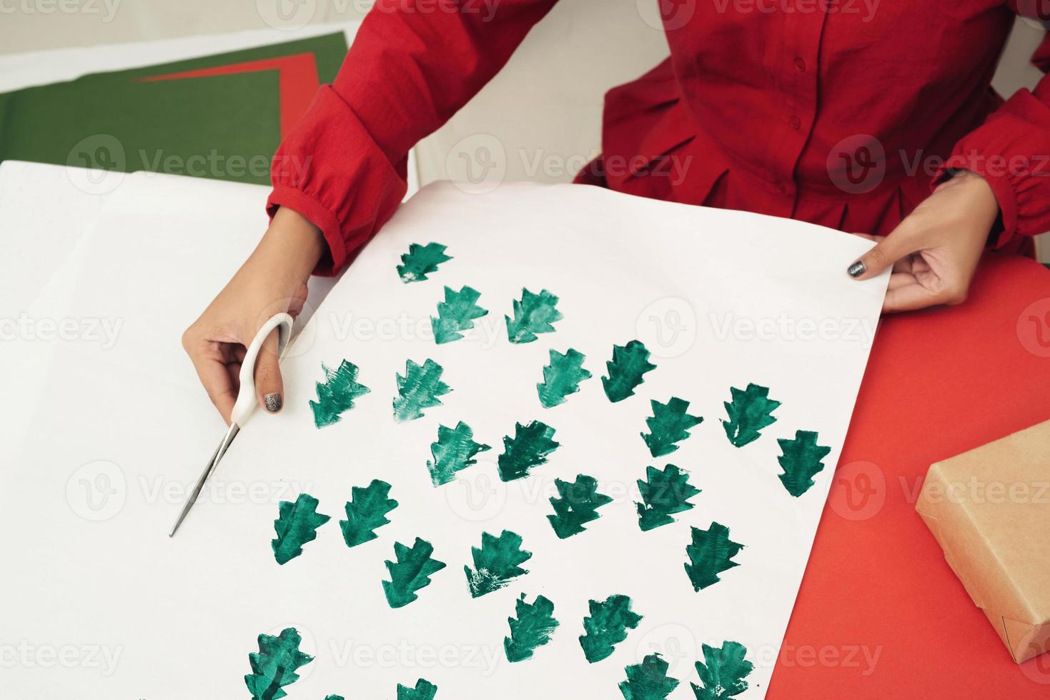 Woman cutting kraft paper and making envelopes at workshop, studio. Handmade and Xmas concept photo