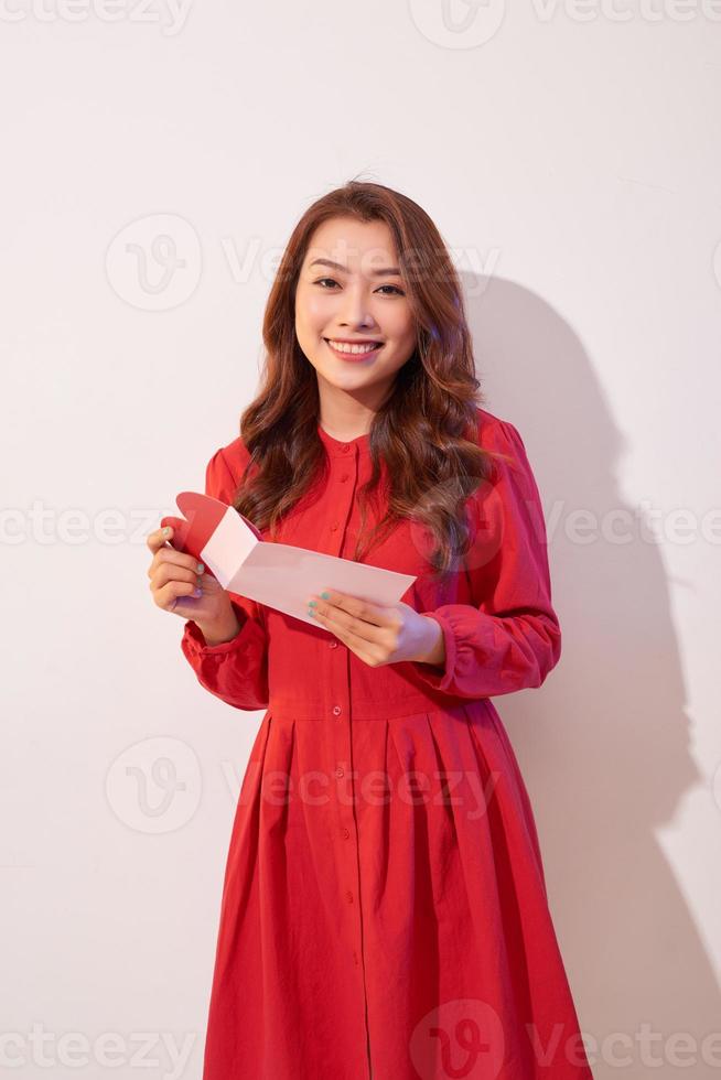 mujer feliz disfrutando de la tarjeta de felicitación, leyendo con placer la carta de amor, celebrando el día de san valentín en casa foto