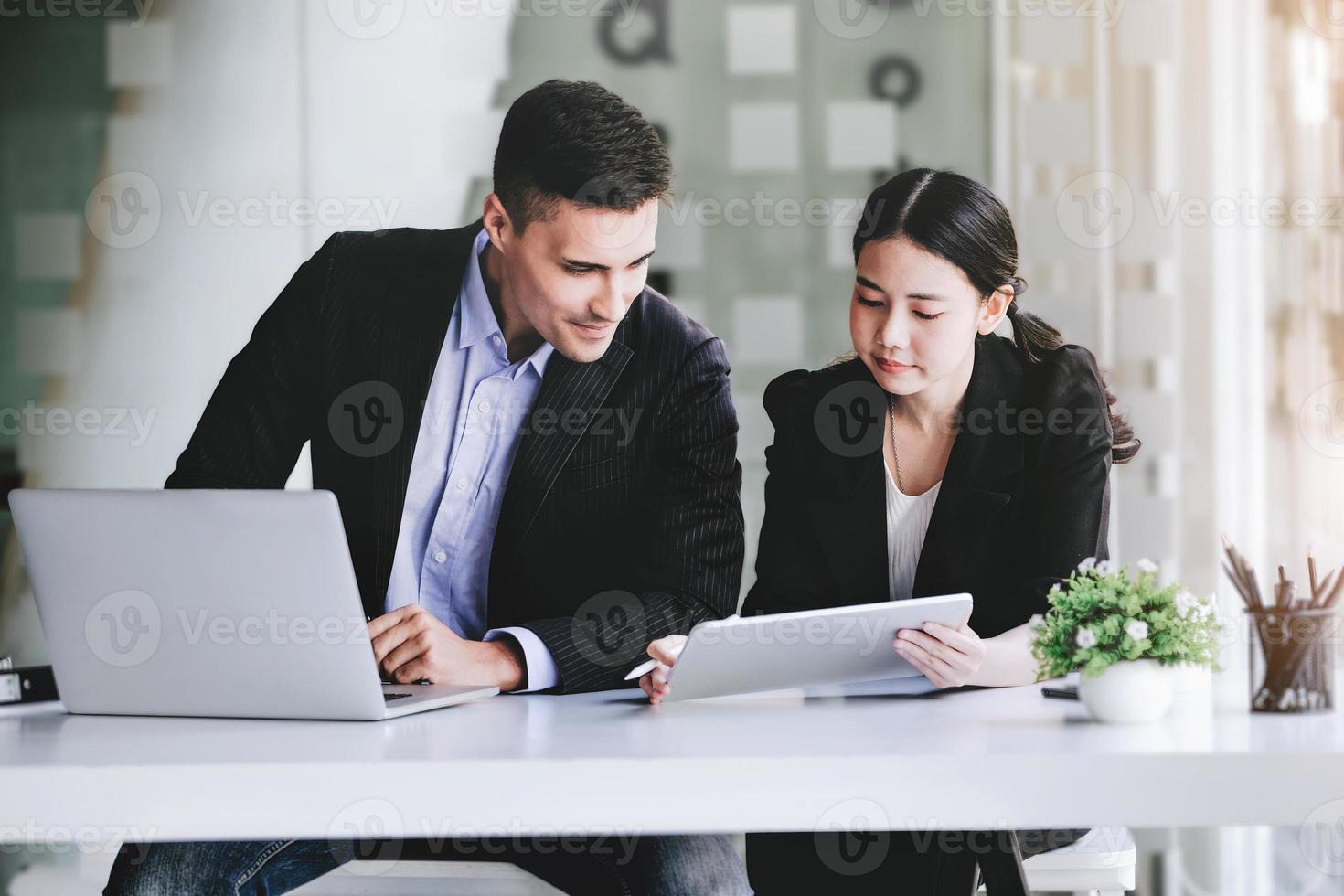 At the consultation, a male adviser  point at a tablet to explain the profit restructuring to female business owners. photo
