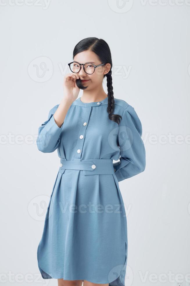 Happy charming lady with two pigtails playing with her hair, posing isolated over white background photo