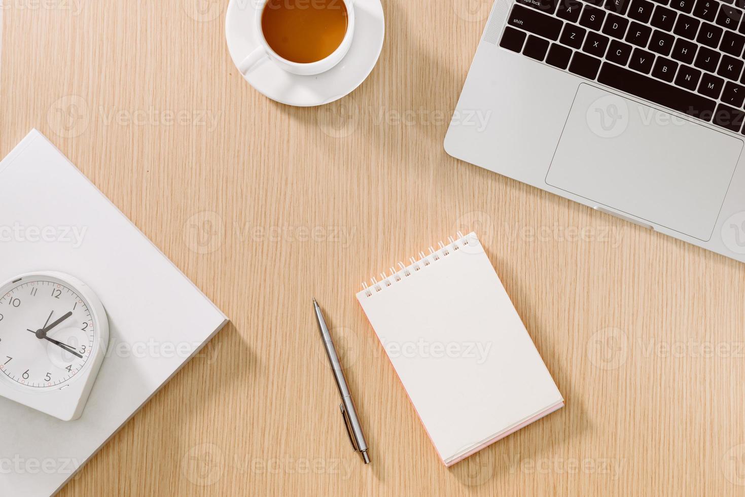 Office desk table with laptop, smart phone, cup of coffee, pen, pencil and notebook. Office supplies and gadgets on desk table. Working desk table concept. photo