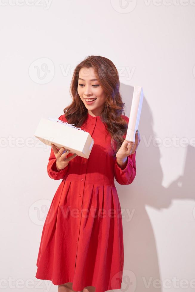 Portrait of a happy smiling girl opening a gift box isolated over white background photo