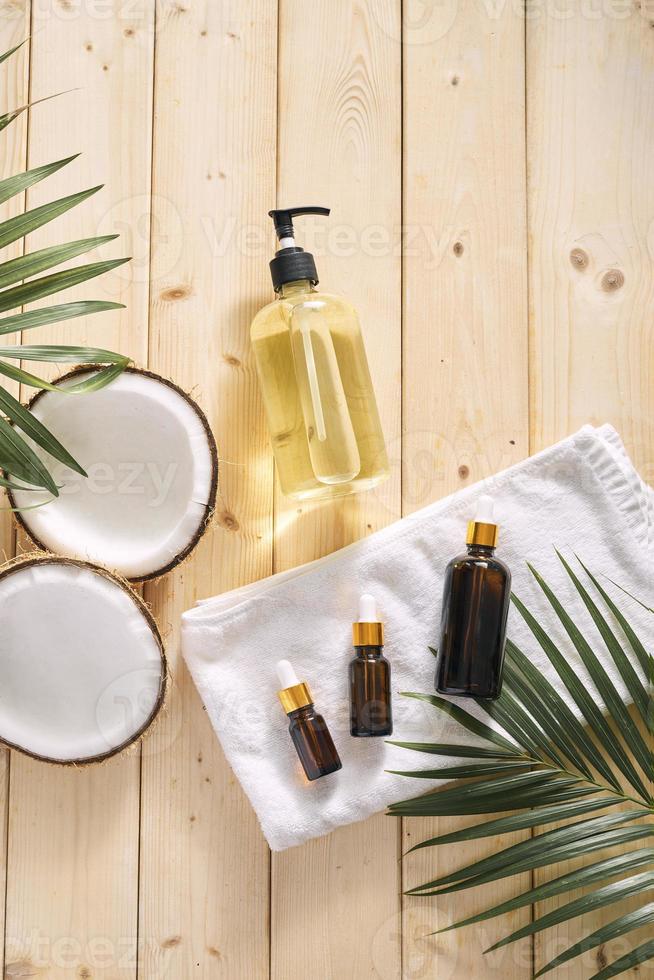 Cracked coconut and a bottle of oil on the table - spa, skincare, haircare and relaxation concept photo