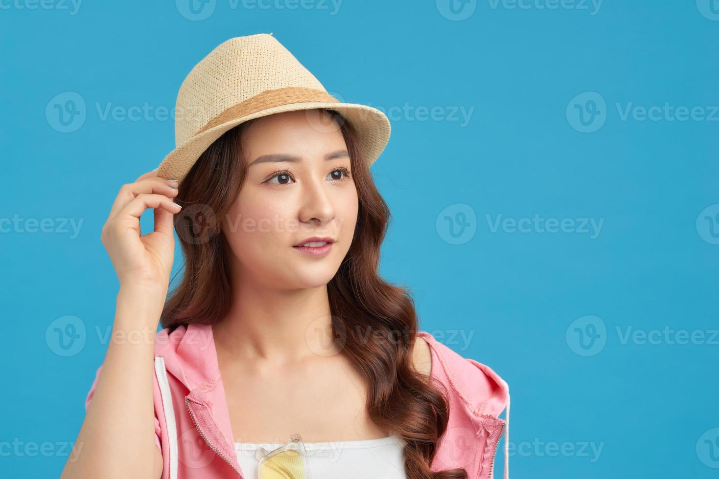 Elegant young attractive woman wearing straw hat and sunglasses, thinking about her summer vacation. photo