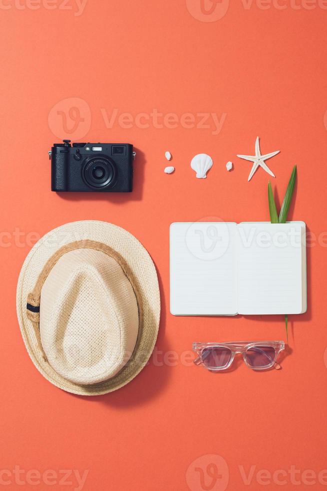 Flat lay beach accessories sunglasses, hat, camera with palm branches and shells. photo
