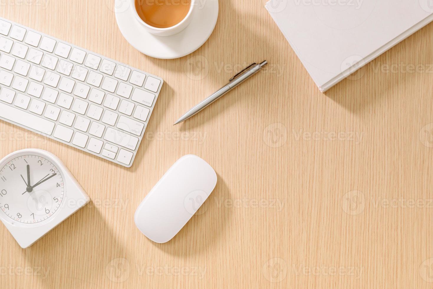 Modern white office desk with keyboard, mouse, oclock, book, pen and cup of coffee.Top view with copy paste. Business and strategy concept mockup. photo