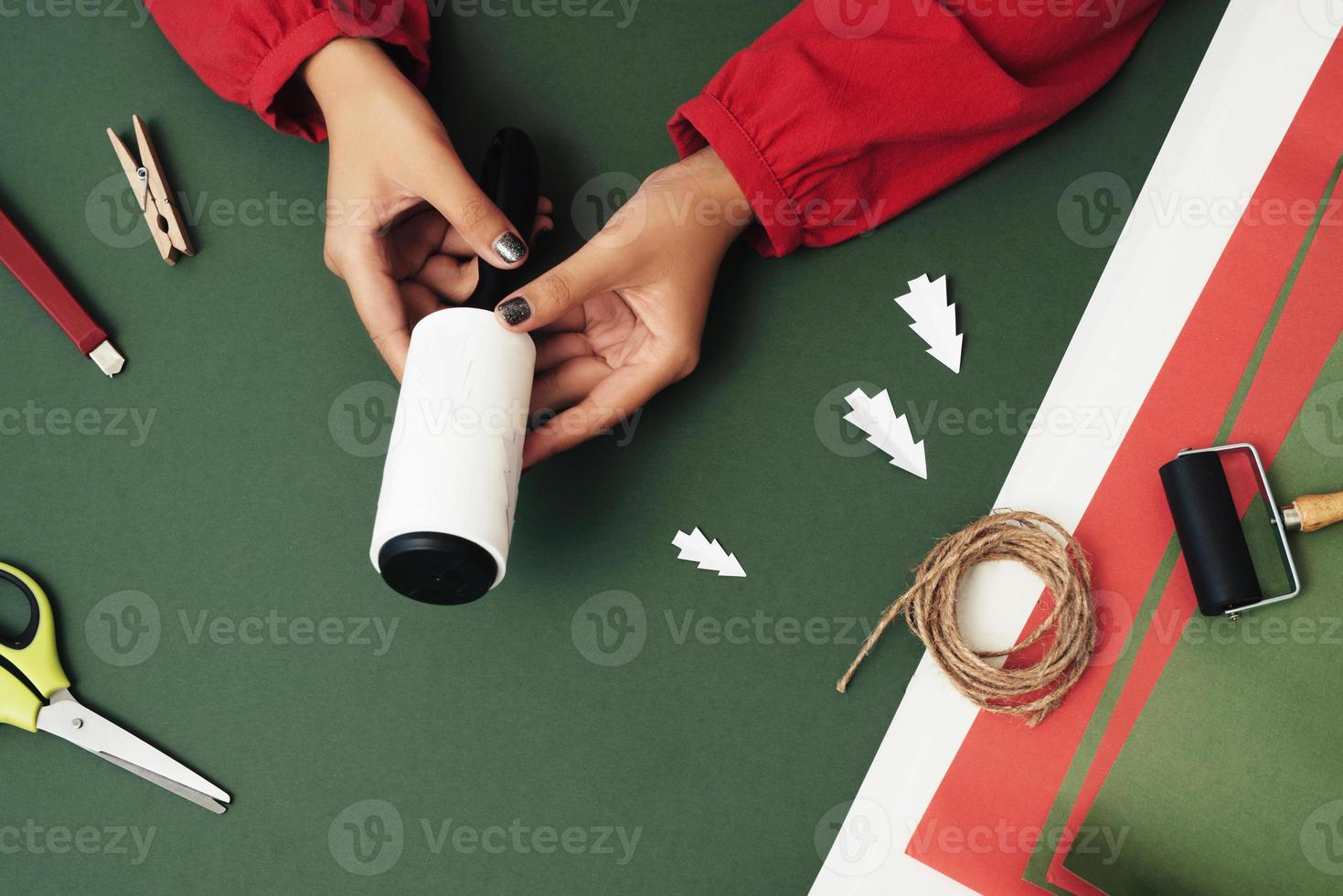 cerca de las manos de la mujer haciendo artesanías para la decoración navideña. concepto de navidad foto