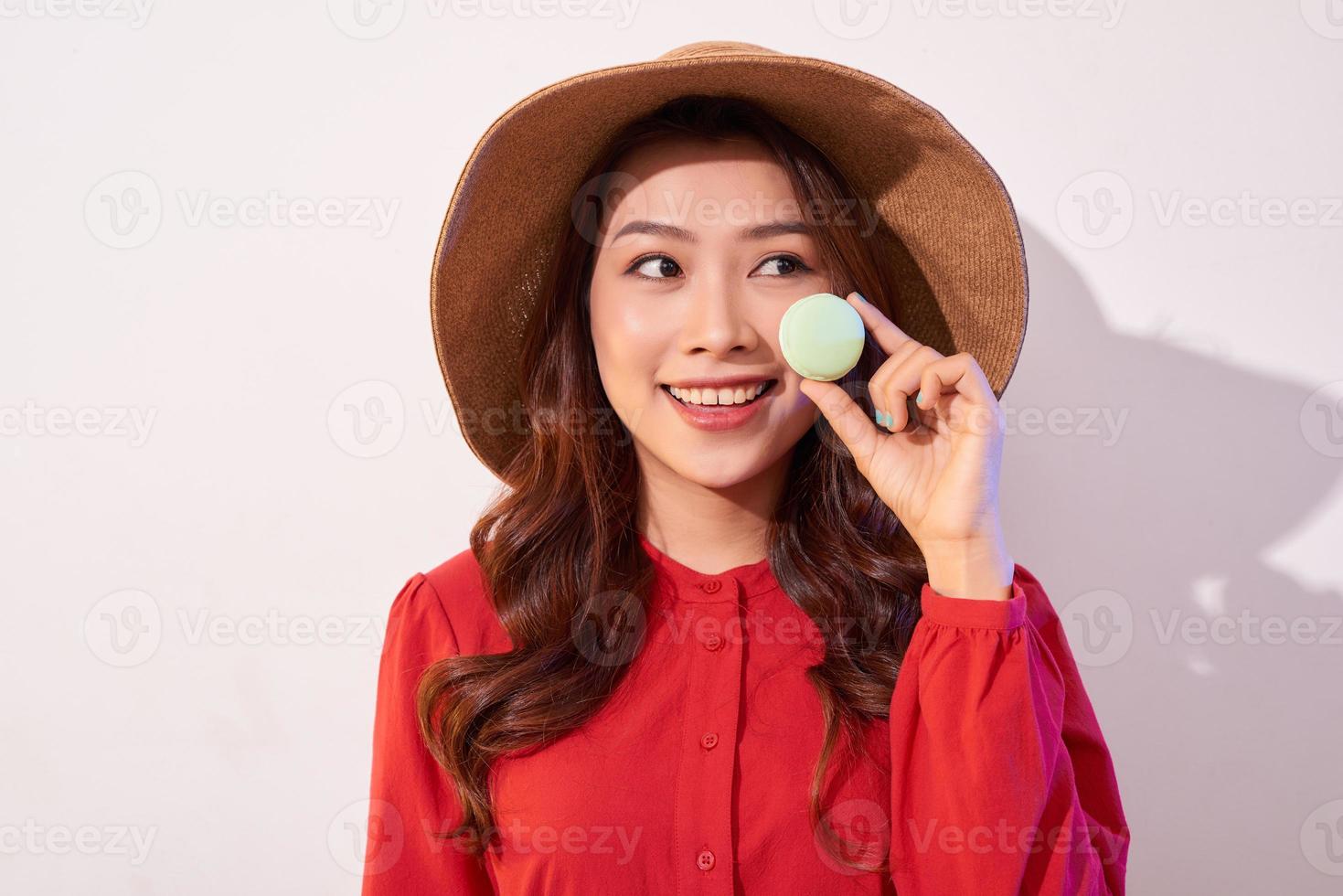 Young woman standing with french sweet cookie macaron over white background photo