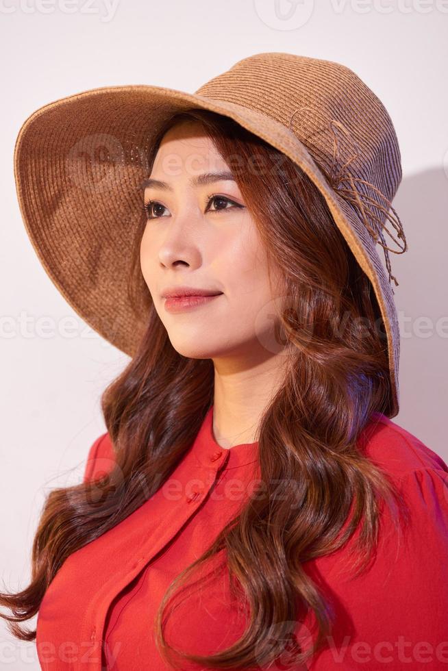 Blissful lady with broad smile posing in sunny day. Laughing girl in red clothes and trendy straw hat enjoying good weather in weekend. photo