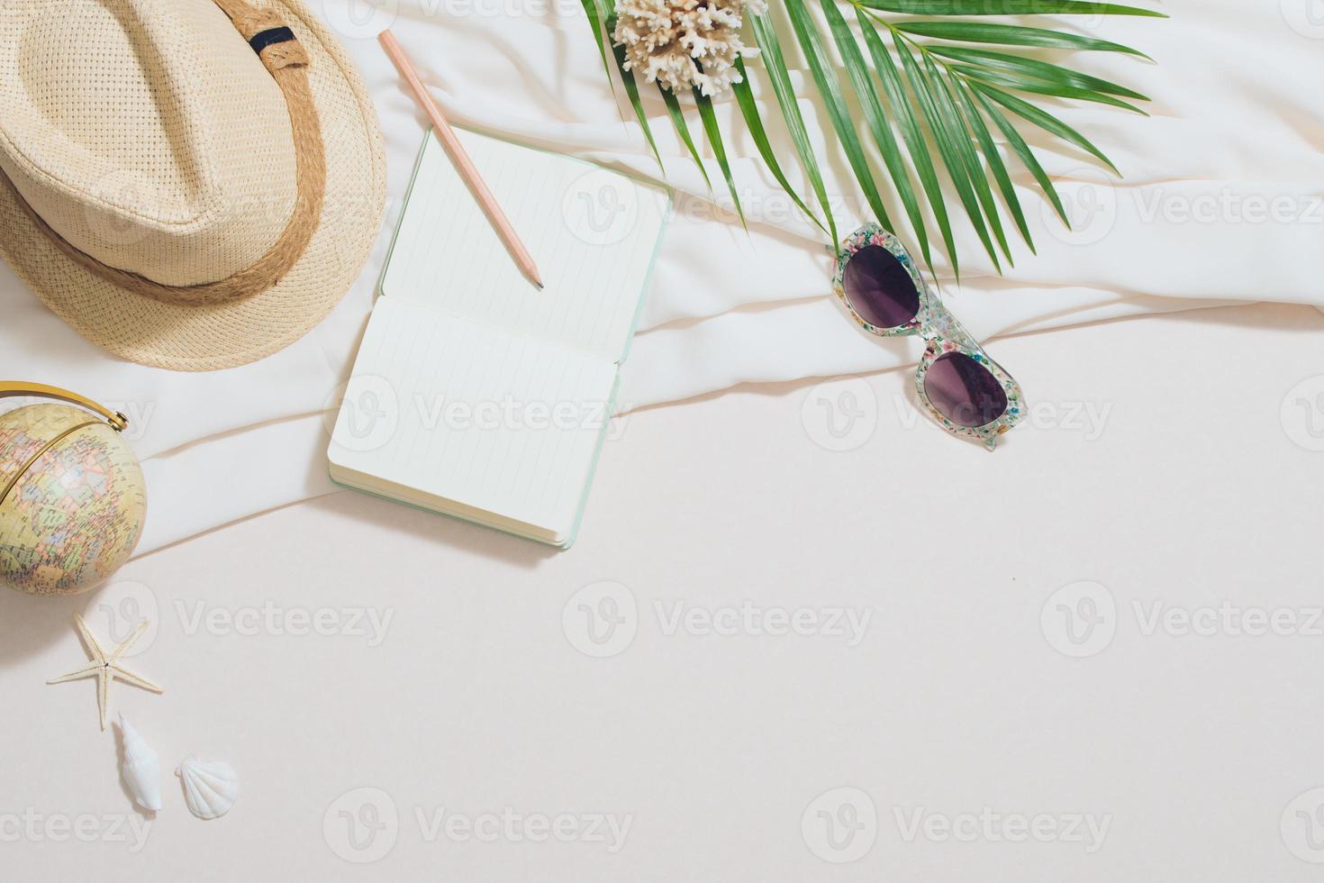 Composition of sunglasses with notebook and palm leaves photo