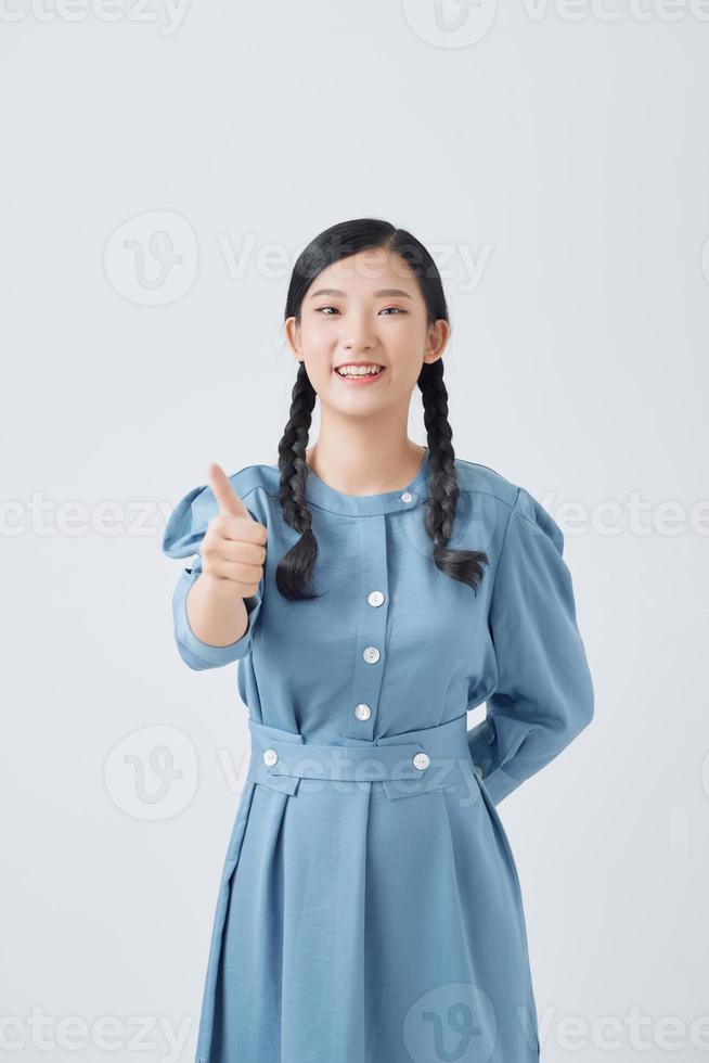 Young Asian woman showing thumb isolated on white background. photo