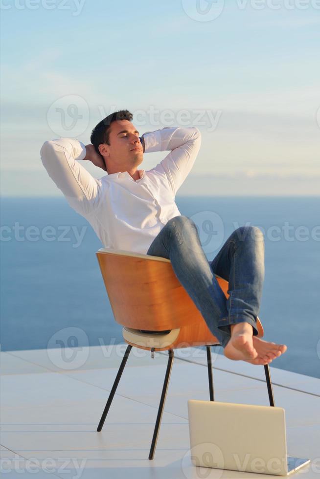 relaxed young man at home on balcony photo