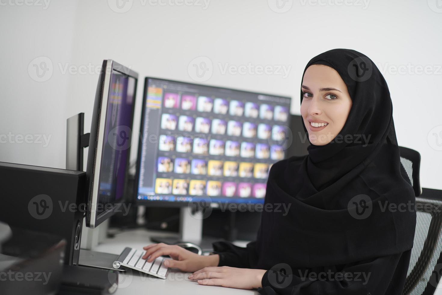 Young muslim girl working on the computer from home photo