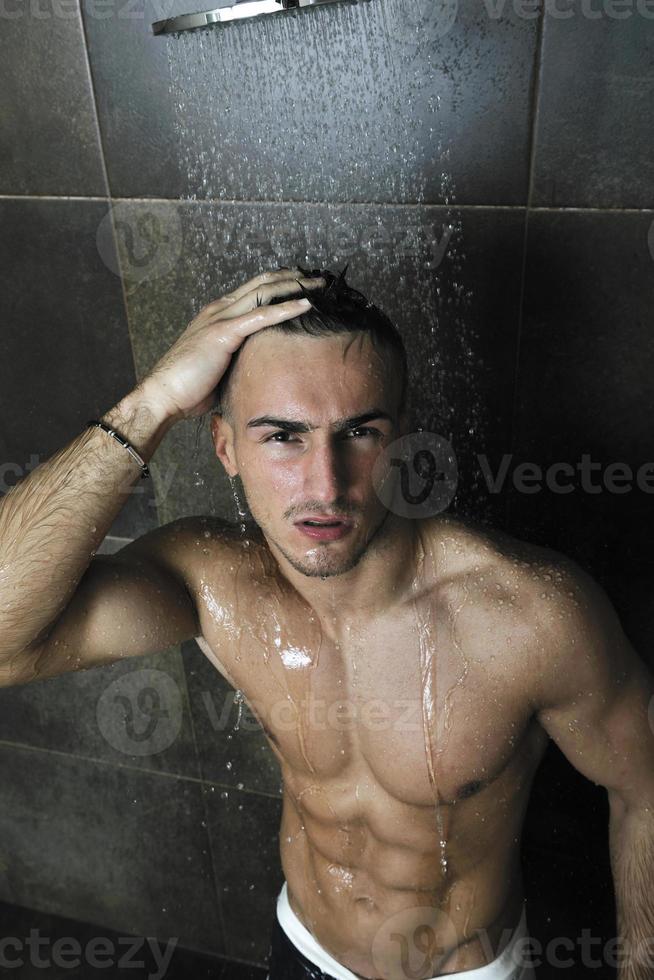 hombre guapo debajo de la ducha de hombre foto