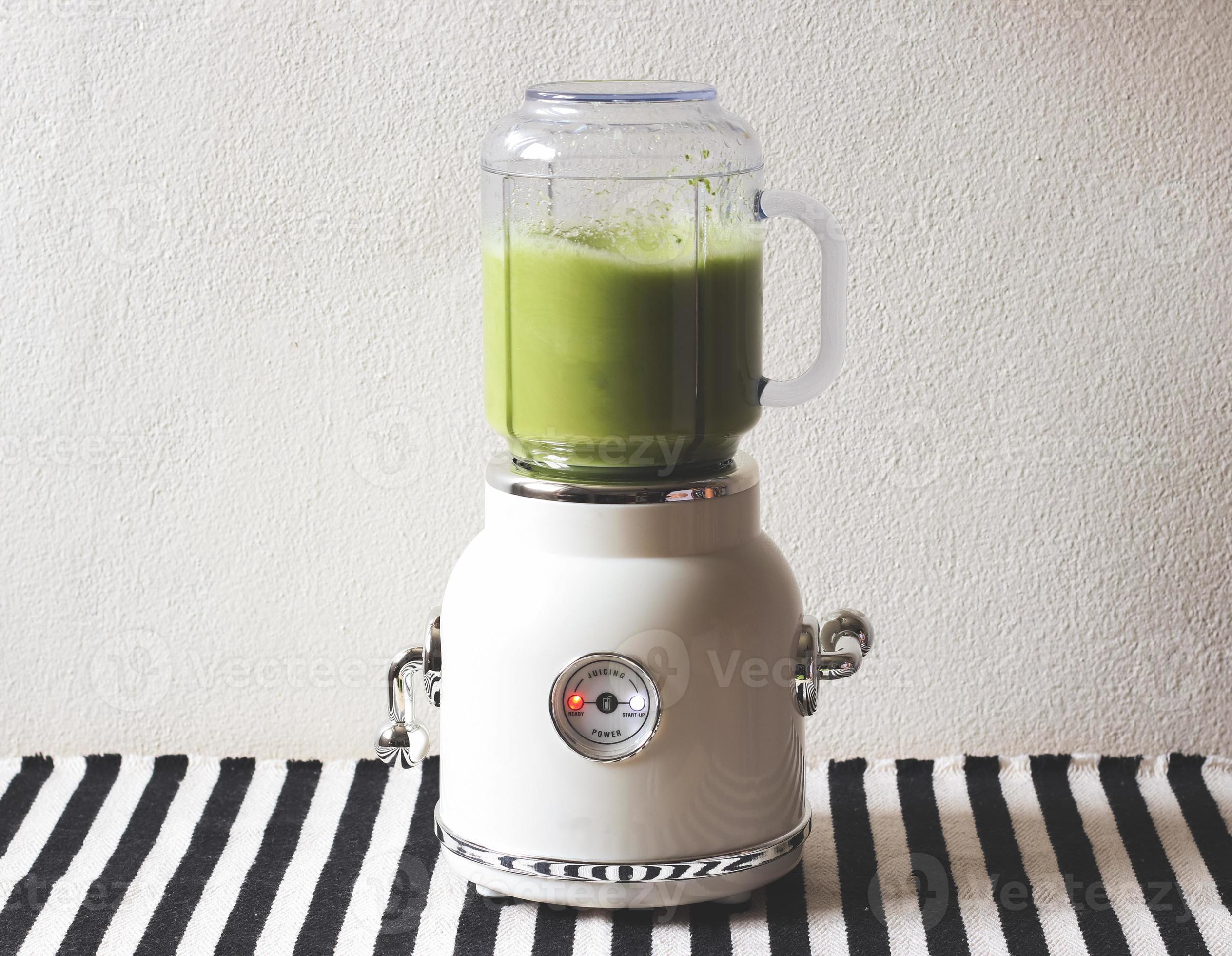 https://static.vecteezy.com/system/resources/previews/010/847/980/large_2x/white-vintage-blender-or-smoothie-maker-machine-working-on-making-green-smoothie-on-black-and-white-stripe-table-cloth-and-white-wall-healthy-drink-making-photo.jpg
