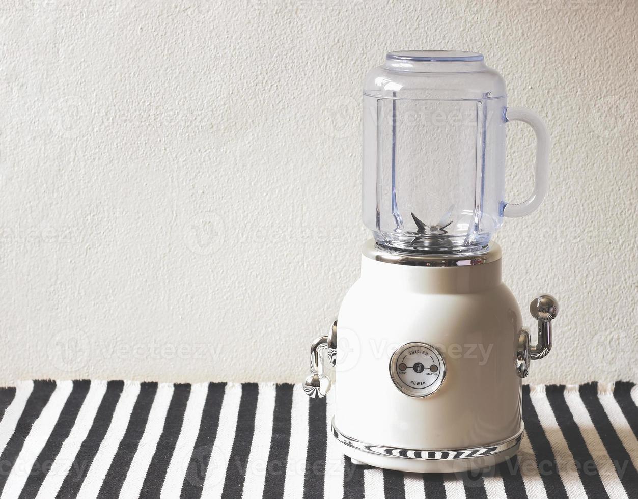 white vintage blender or smoothie maker  on  black and white stripe table cloth and white wall. photo