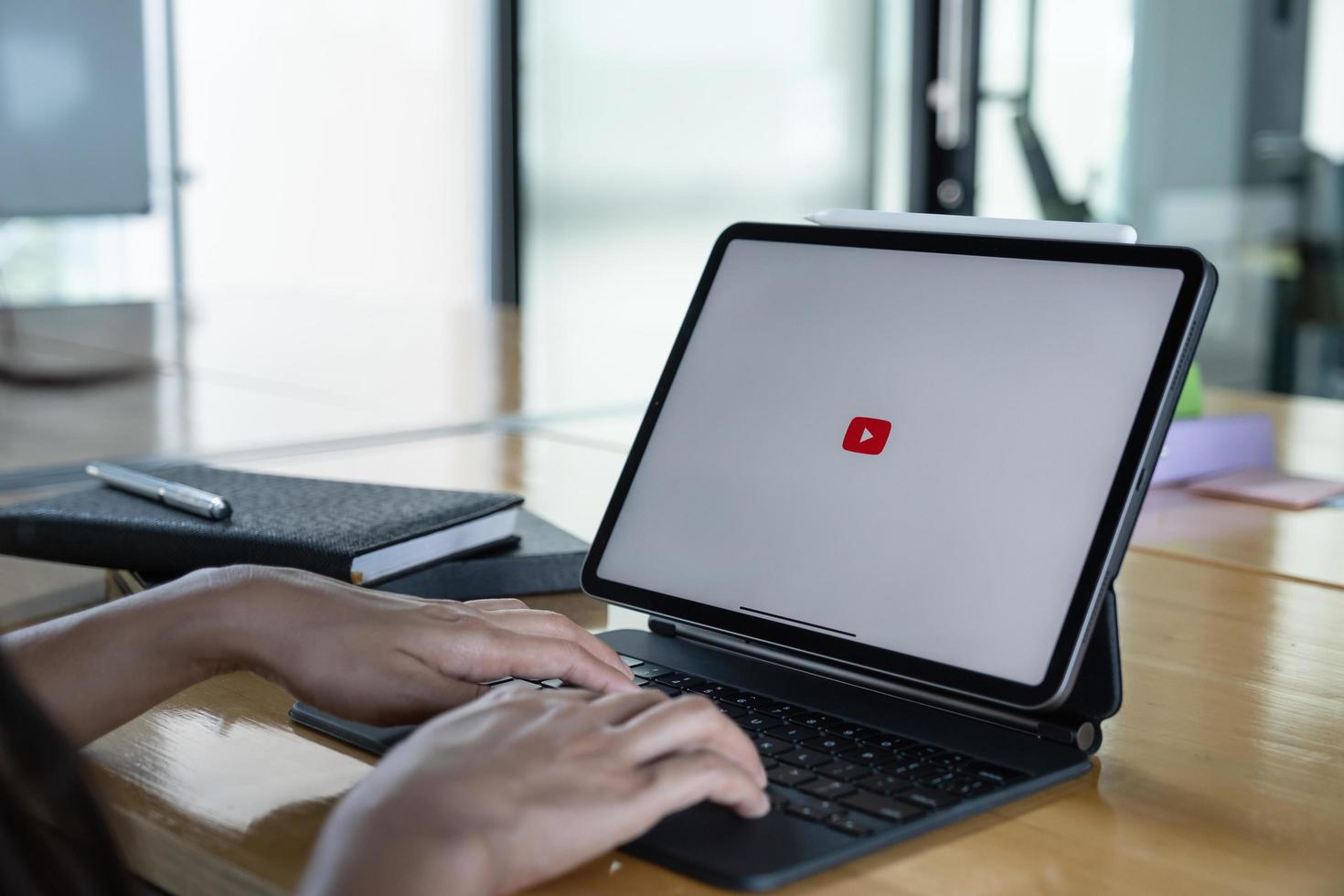 CHIANG MAI,THAILAND - SEP 07, 2020  Yotuber using youtube app by iPad. YouTube app on the screen lying on old wood desk. YouTube is the popular online video sharing website. photo