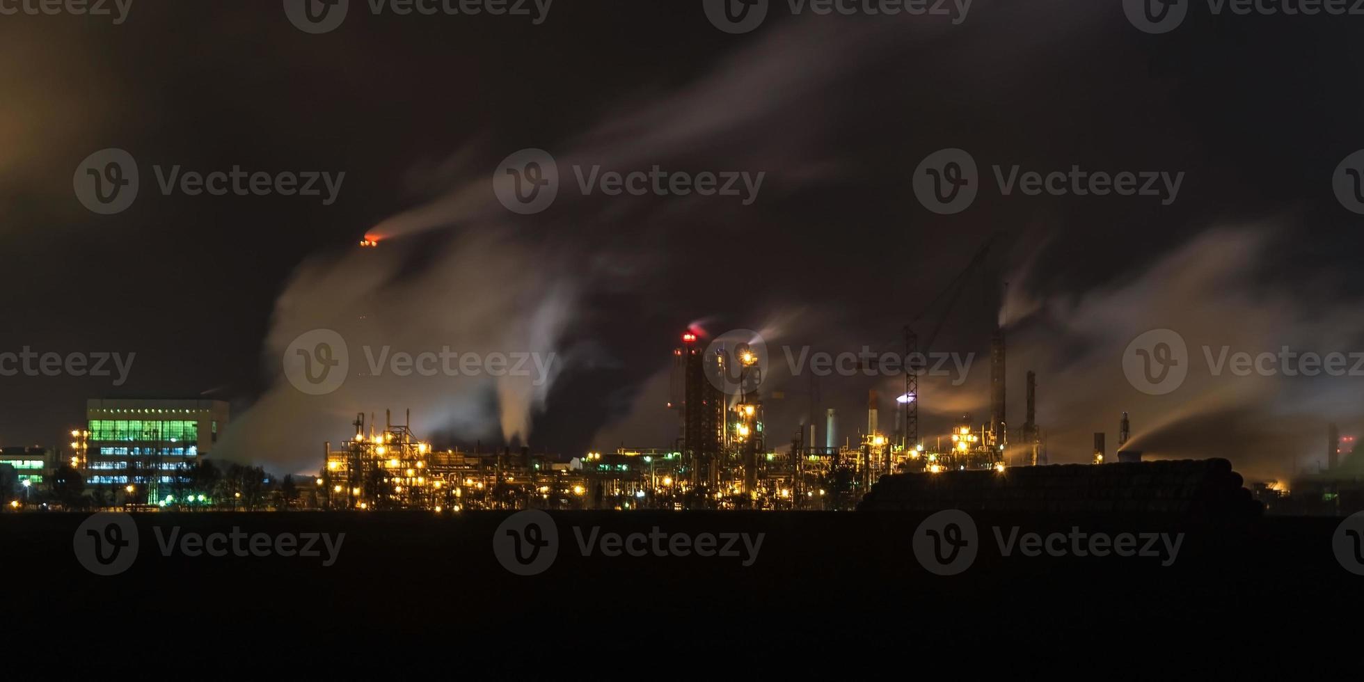 paisaje industrial nocturno contaminación ambiental residuos de central térmica. grandes tuberías de la planta empresarial de la industria química foto