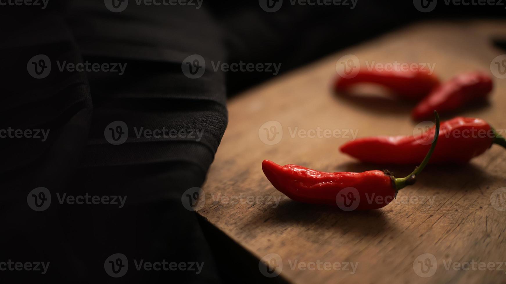 close up chili in the cutting board with black background texture photo