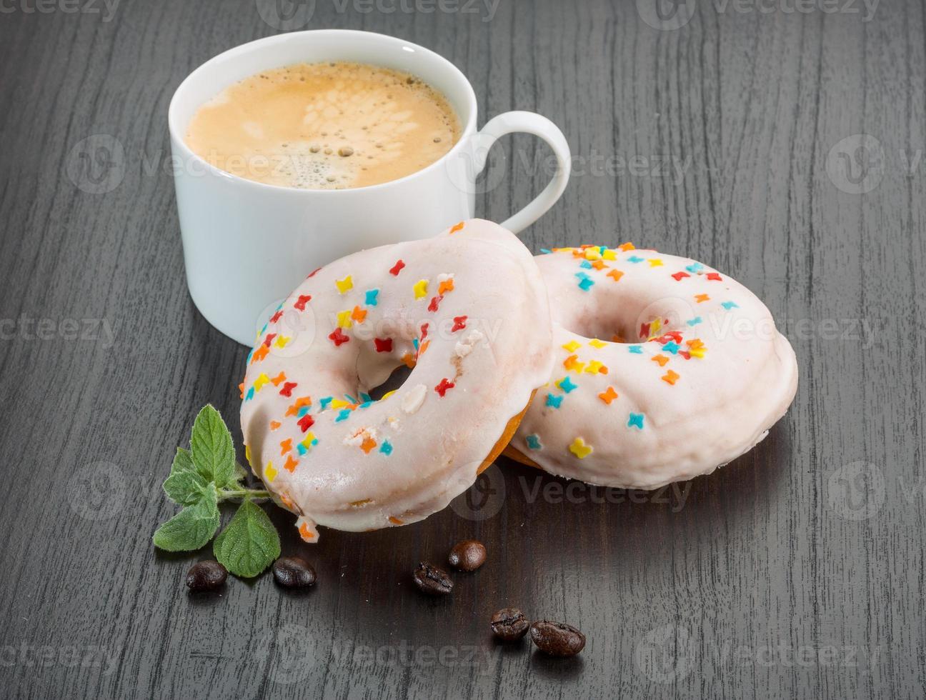 Coffee with donuts on wooden background photo