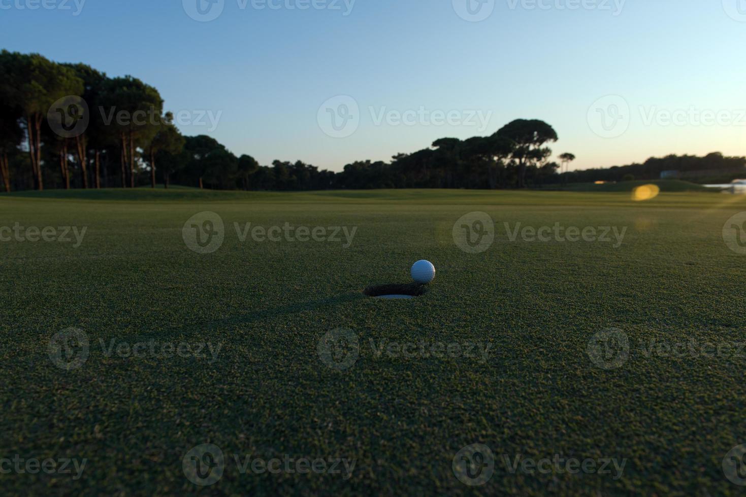 pelota de golf al borde del hoyo foto