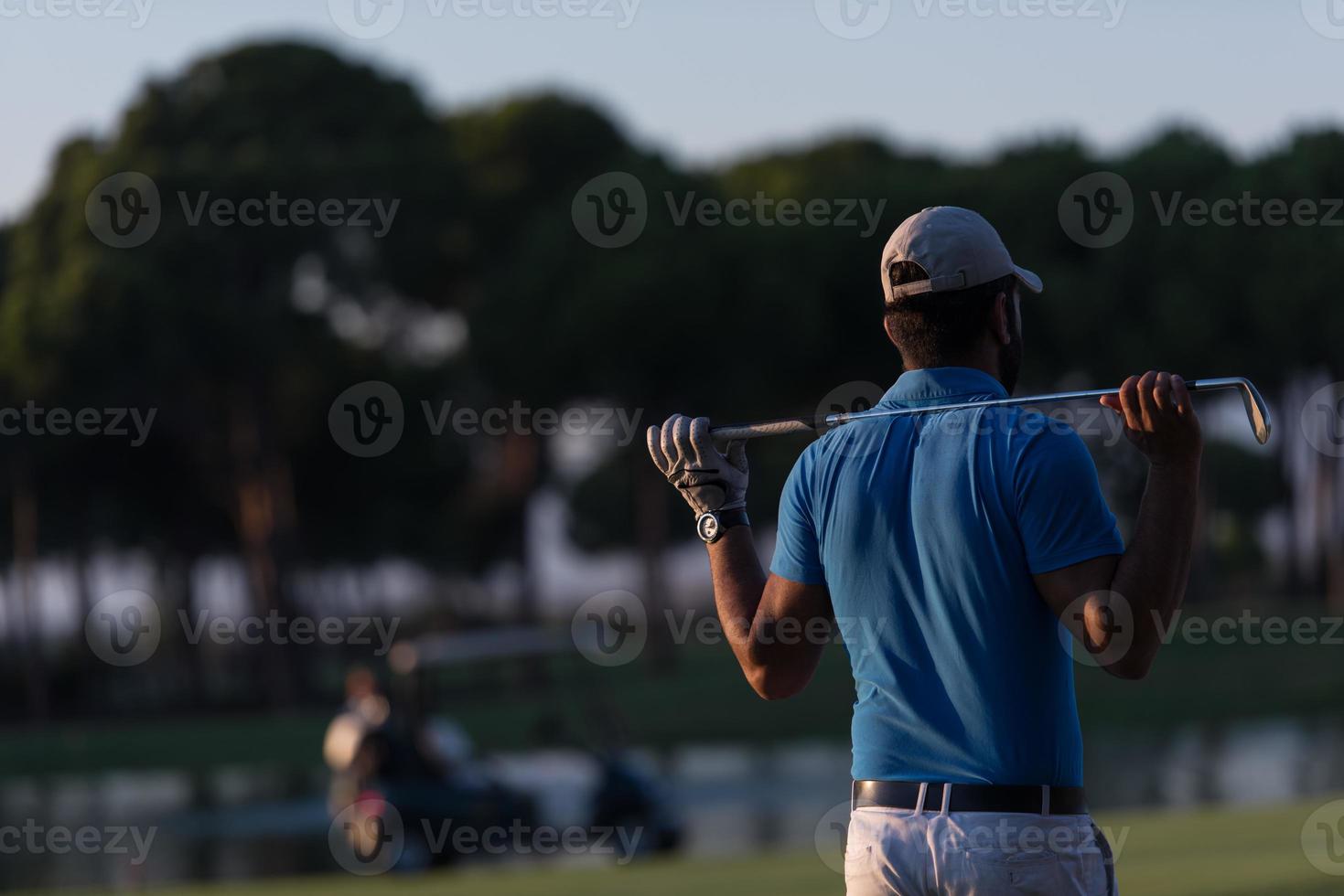 golfer from back at course looking to hole in distance photo