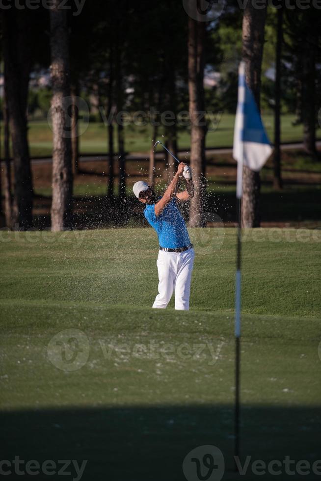 pro golfer hitting a sand bunker shot photo