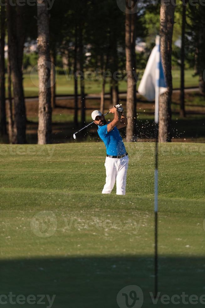 pro golfer hitting a sand bunker shot photo