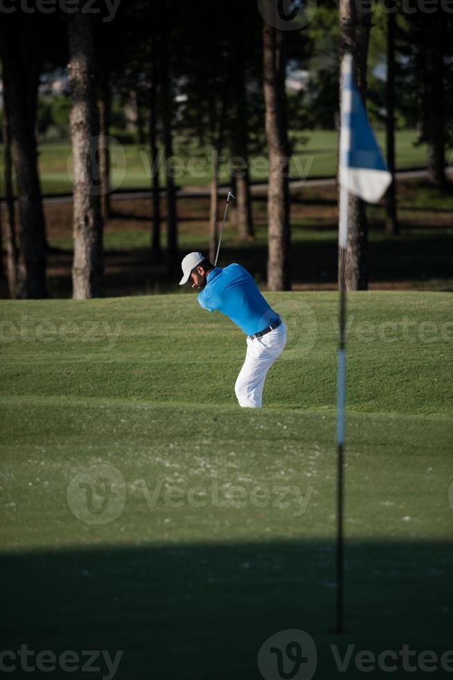 pro golfer hitting a sand bunker shot photo
